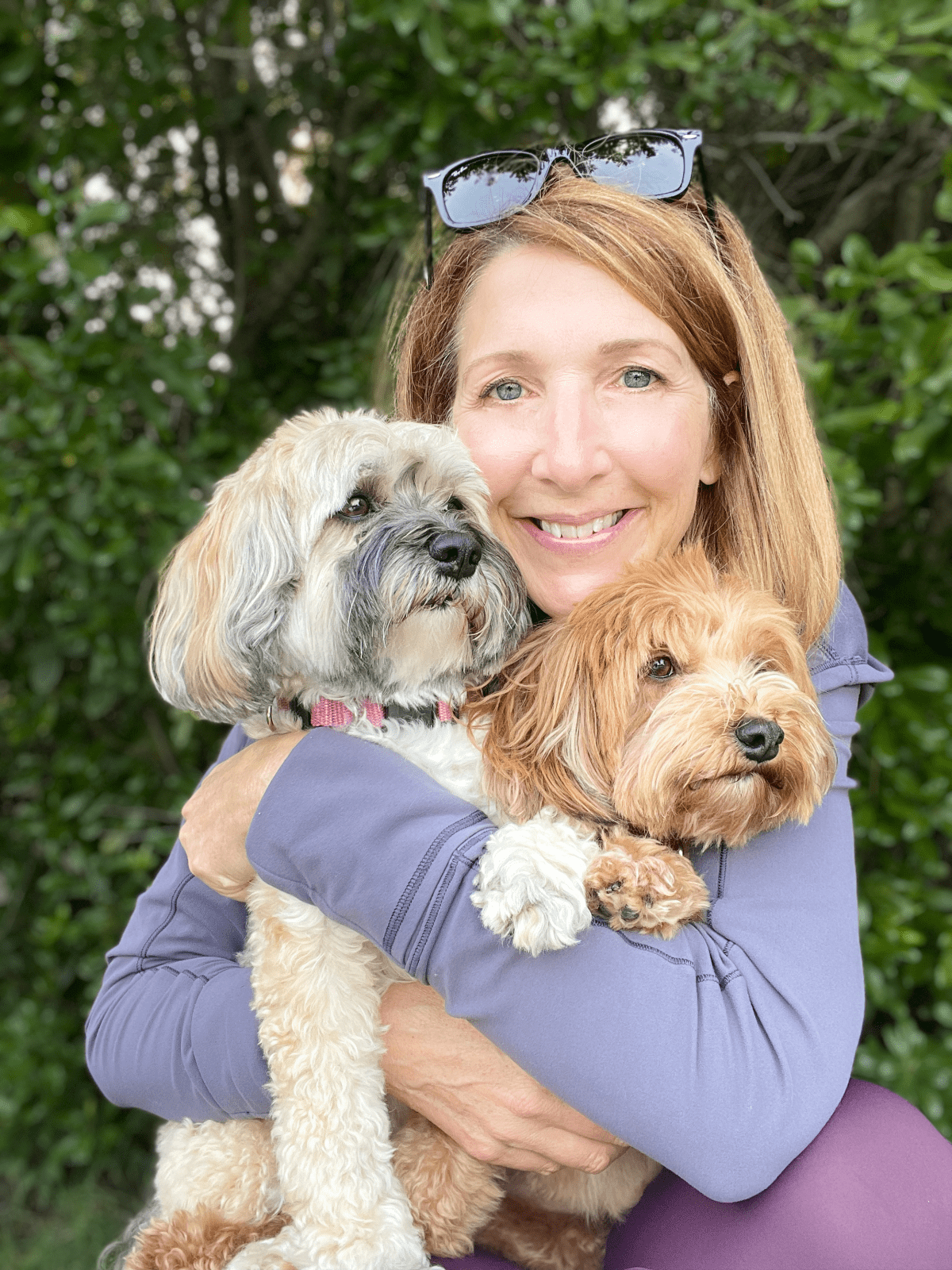 woman hugging two dogs